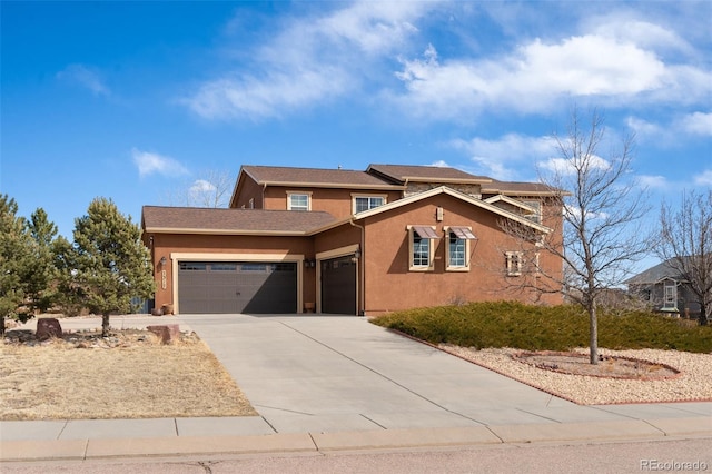 view of front of home featuring concrete driveway, an attached garage, and stucco siding