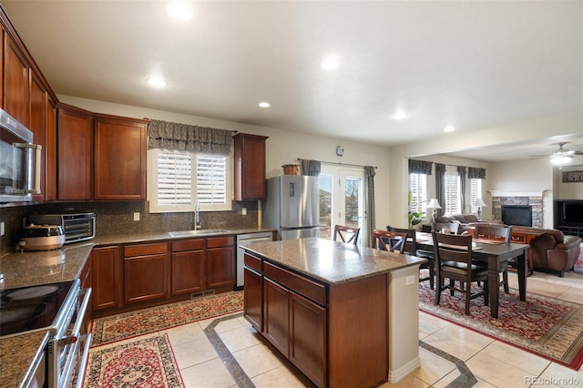 kitchen featuring appliances with stainless steel finishes, plenty of natural light, a sink, and decorative backsplash