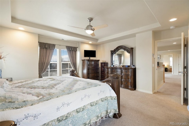 carpeted bedroom featuring a tray ceiling, recessed lighting, a ceiling fan, and baseboards