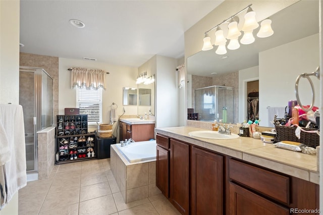 full bath with a stall shower, visible vents, a sink, tile patterned flooring, and two vanities