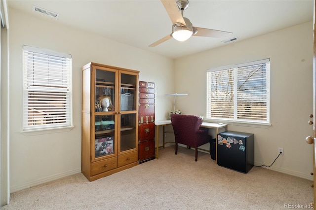 carpeted office with ceiling fan, visible vents, and baseboards