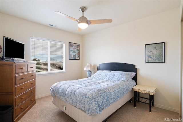 bedroom featuring light colored carpet, ceiling fan, visible vents, and baseboards