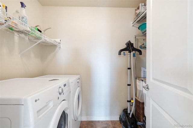 clothes washing area with laundry area, baseboards, and washing machine and clothes dryer