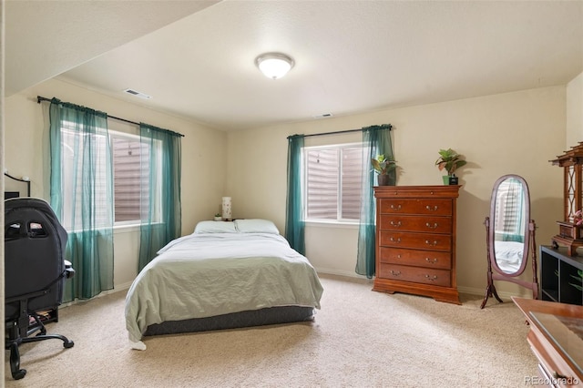 carpeted bedroom featuring multiple windows, visible vents, and baseboards