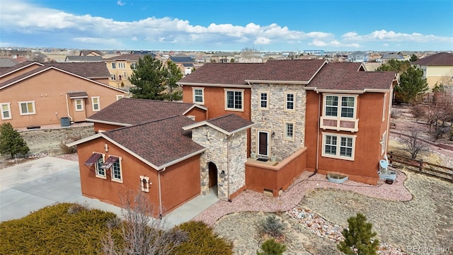 view of front of home with stone siding, a residential view, and stucco siding