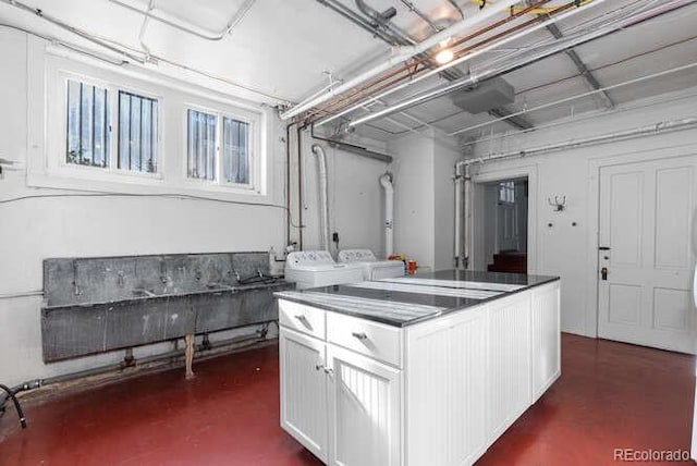 kitchen with a center island, washer and dryer, and white cabinets