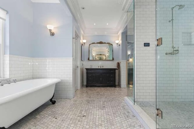 bathroom featuring vanity, crown molding, shower with separate bathtub, and tile walls