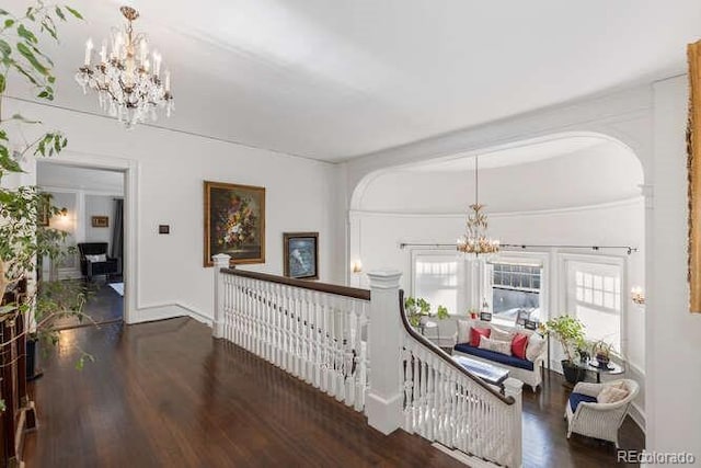 hall with dark wood-type flooring and a chandelier