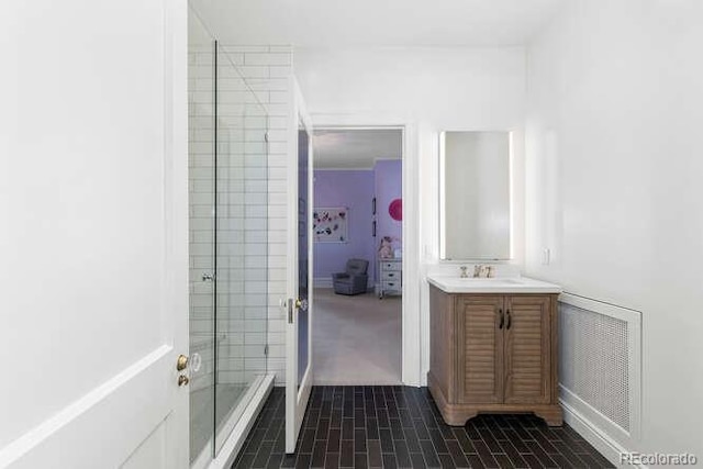 bathroom featuring vanity and a shower with door