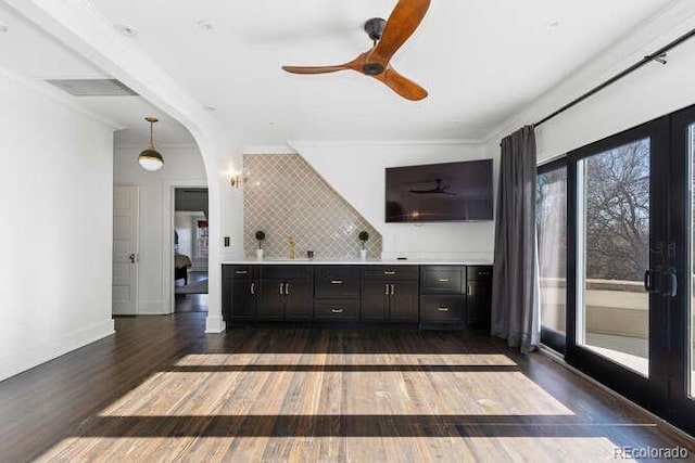 interior space featuring dark hardwood / wood-style floors, tasteful backsplash, hanging light fixtures, ceiling fan, and crown molding