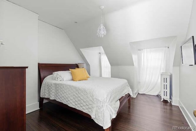 bedroom with radiator heating unit, dark wood-type flooring, and vaulted ceiling