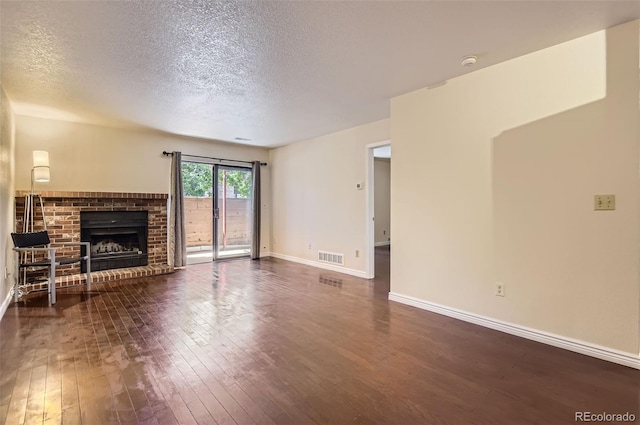 2223 S Buckley Rd Unit 102, Aurora, CO 80013 - unfurnished living room featuring a textured ceiling, dark wood-type flooring, and a fireplace