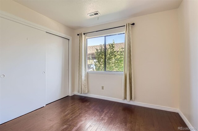 2223 S Buckley Rd Unit 102, Aurora, CO 80013 - unfurnished bedroom featuring hardwood / wood-style floors and a closet