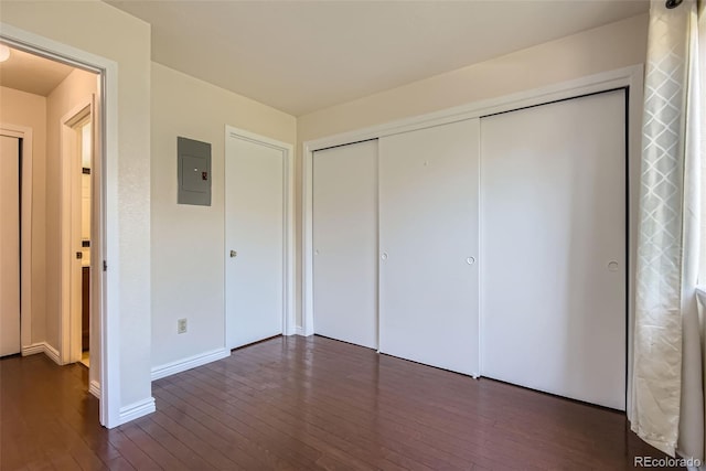 2223 S Buckley Rd Unit 102, Aurora, CO 80013 - unfurnished bedroom featuring electric panel, dark wood-style flooring, and a closet