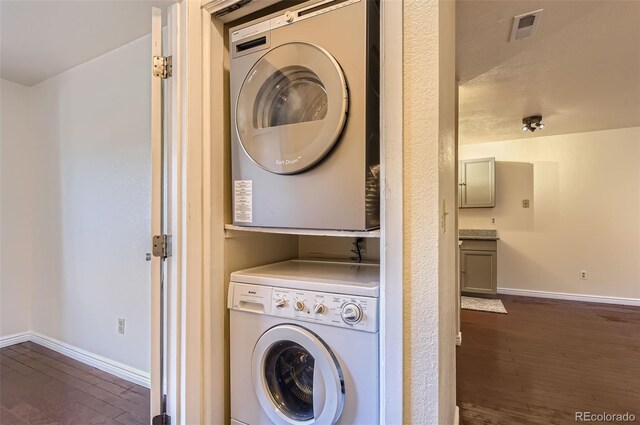 2223 S Buckley Rd Unit 102, Aurora, CO 80013 - laundry room with stacked washing machine and dryer and dark wood-style floors