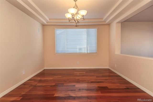 unfurnished room with a chandelier, a raised ceiling, and dark wood-type flooring