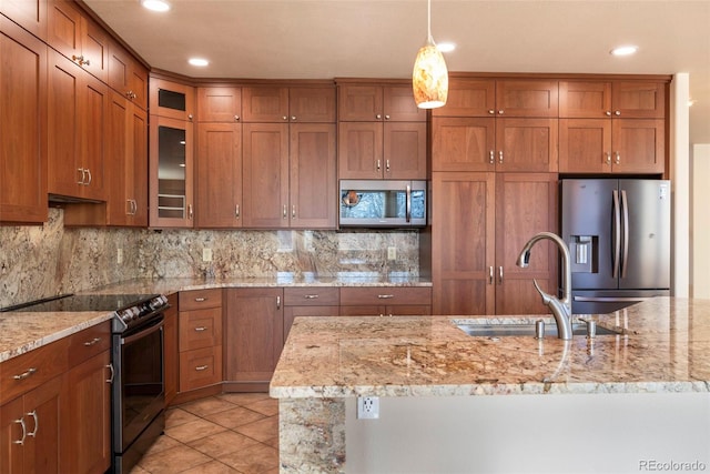 kitchen with light stone countertops, sink, backsplash, pendant lighting, and appliances with stainless steel finishes