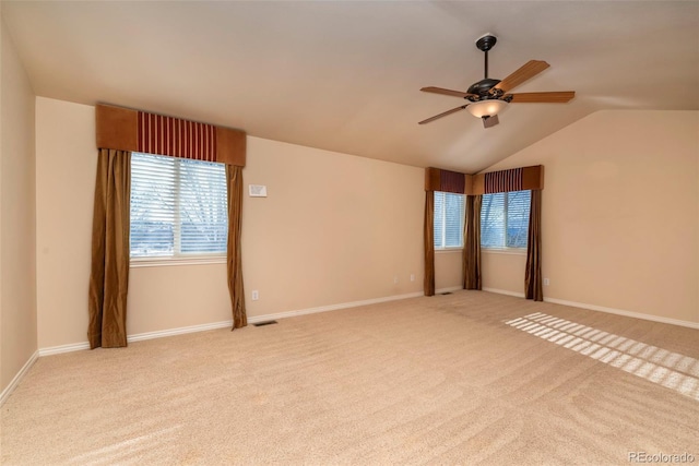 carpeted empty room with ceiling fan and vaulted ceiling