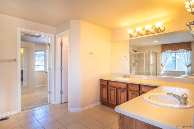 bathroom featuring tile patterned flooring, vanity, and a shower with shower door