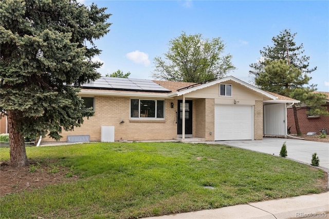 single story home with a front lawn, solar panels, and a garage