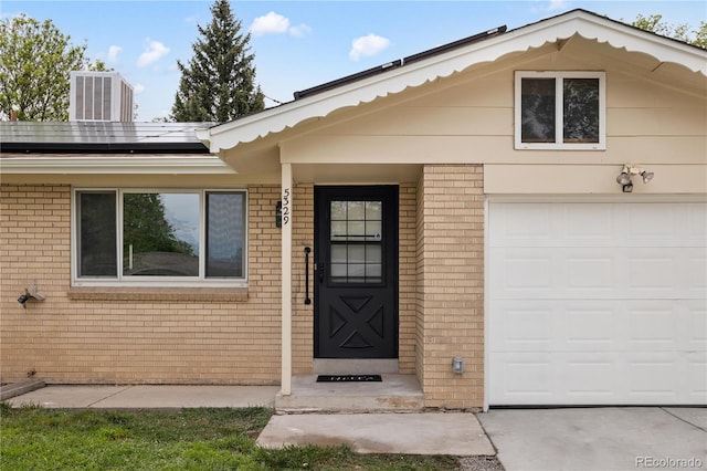 property entrance featuring a garage and solar panels