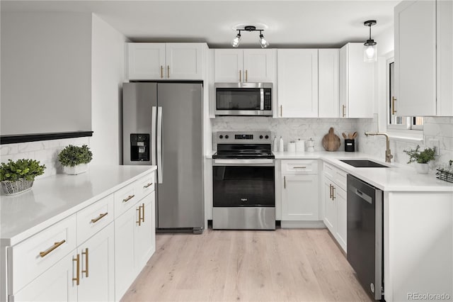 kitchen featuring white cabinetry, stainless steel appliances, tasteful backsplash, pendant lighting, and sink