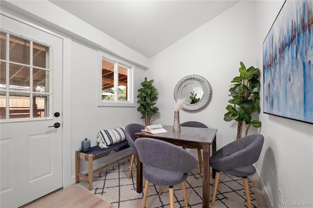 dining area featuring light wood-type flooring and lofted ceiling