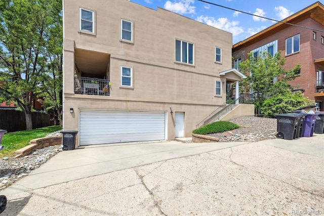 3030 Wyandot St Unit 4, Denver, CO 80211 - rear view of property with concrete driveway, an attached garage, and stucco siding