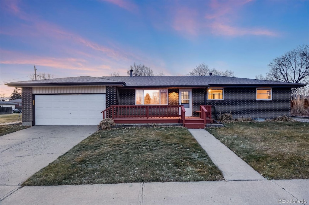 ranch-style home featuring a garage and a yard