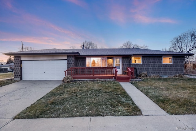 ranch-style home featuring a garage and a yard