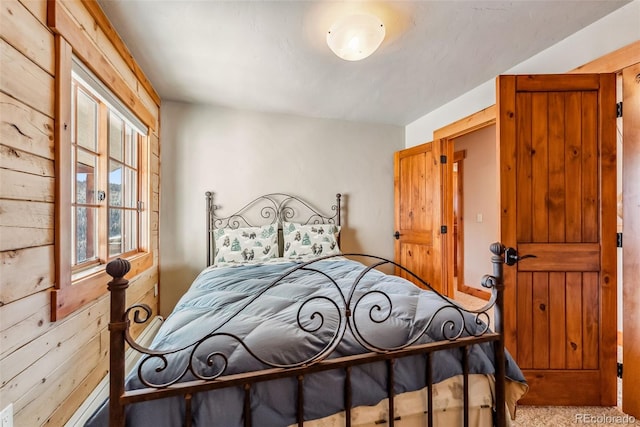 bedroom featuring wood walls and carpet flooring