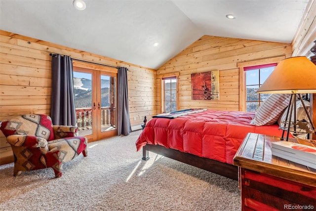 carpeted bedroom with access to outside, wooden walls, multiple windows, and lofted ceiling