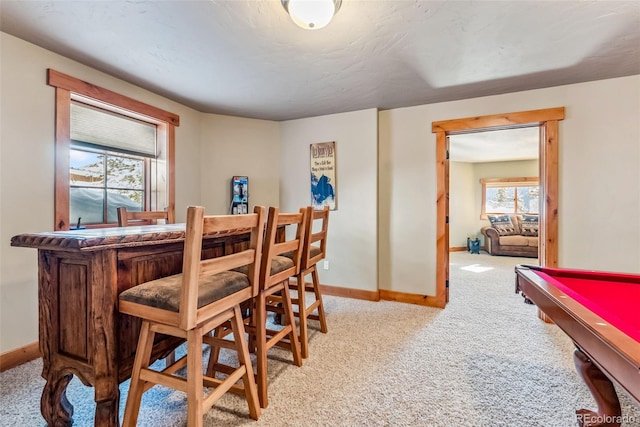 dining room with light carpet, a dry bar, baseboards, and pool table