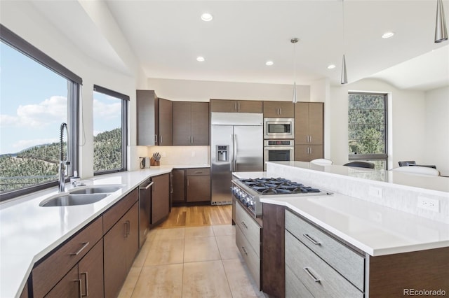 784 Grand Horizon Vw, Manitou Springs, CO 80829 - kitchen with built in appliances, a sink, a center island, dark brown cabinetry, and light countertops