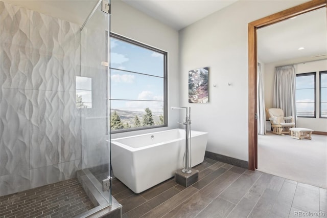 784 Grand Horizon Vw, Manitou Springs, CO 80829 - bathroom with wood finish floors, a shower stall, a freestanding tub, and baseboards