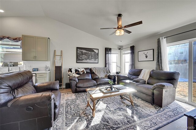 living room with light hardwood / wood-style flooring, sink, vaulted ceiling, and ceiling fan