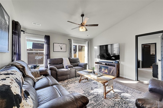 living room featuring lofted ceiling, light hardwood / wood-style flooring, and ceiling fan