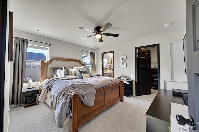 carpeted bedroom featuring multiple windows and ceiling fan