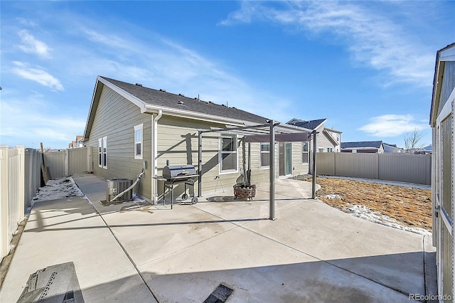 rear view of house featuring central AC unit, a pergola, and a patio area