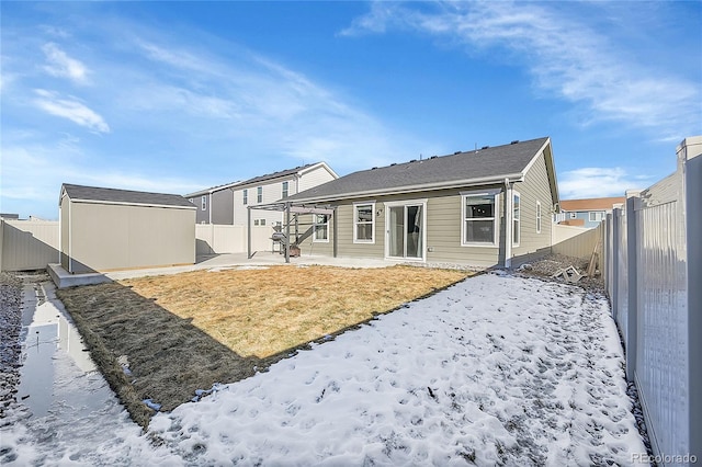 snow covered house featuring a storage unit