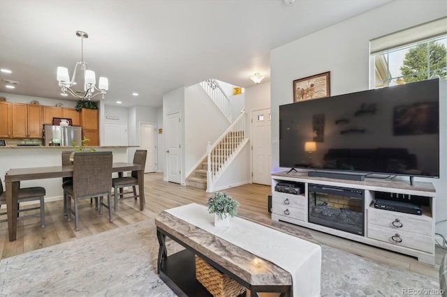 living room featuring an inviting chandelier and light hardwood / wood-style flooring