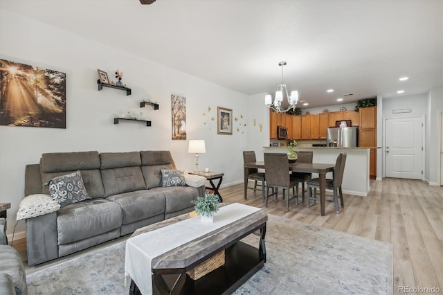 living room with light hardwood / wood-style flooring and a notable chandelier