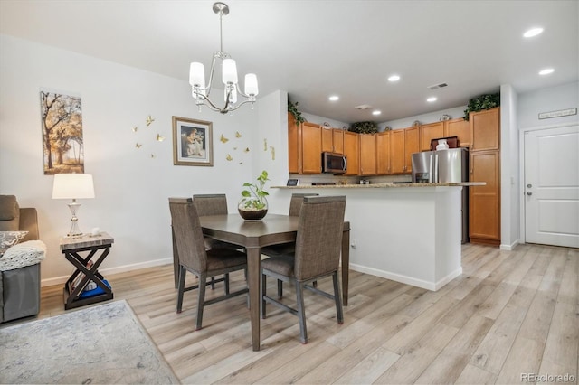 dining room with a chandelier and light hardwood / wood-style flooring