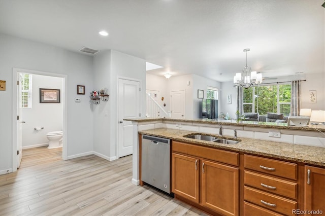 kitchen featuring sink, dishwasher, hanging light fixtures, light stone counters, and light wood-type flooring