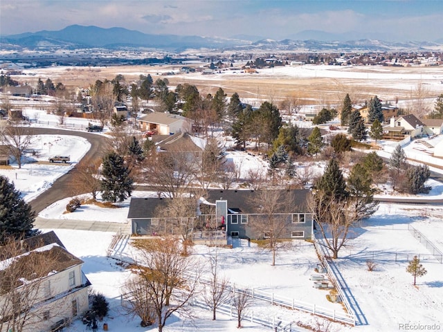 snowy aerial view with a residential view and a mountain view