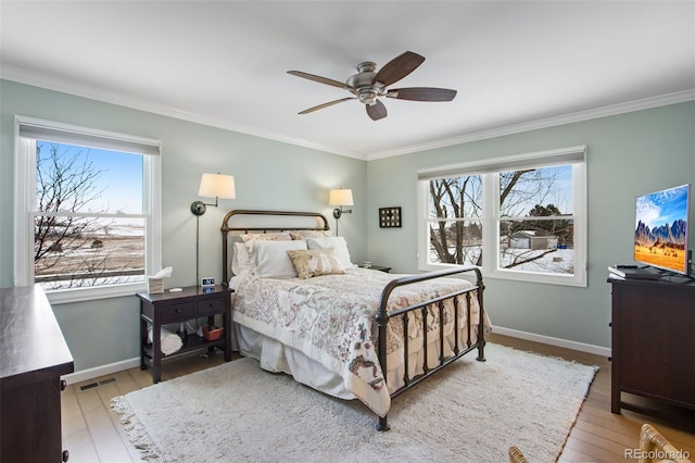 bedroom featuring light wood-type flooring, baseboards, multiple windows, and visible vents