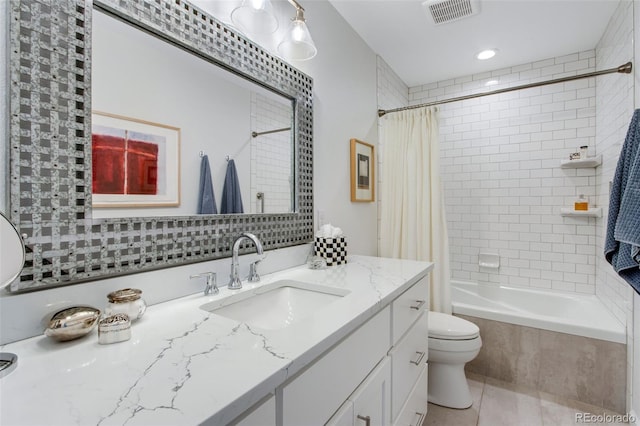 full bathroom featuring visible vents, toilet, tiled shower / bath combo, vanity, and tile patterned floors