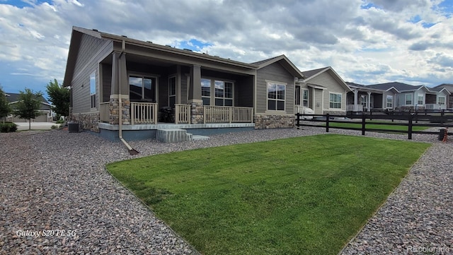 22345 E Bailey Pl, Aurora, CO 80016 - view of front of house featuring stone siding, fence, a front lawn, and cooling unit