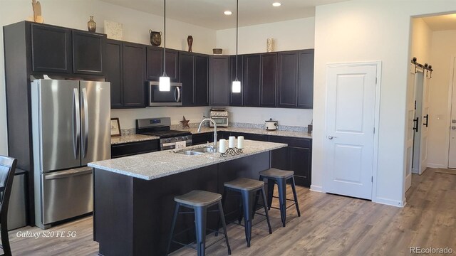 22345 E Bailey Pl, Aurora, CO 80016 - kitchen with a sink, stainless steel appliances, a kitchen breakfast bar, and light wood-style flooring