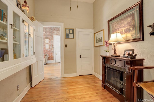 hallway featuring brick wall and light hardwood / wood-style floors